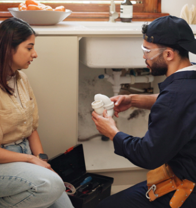 kitchen sink and plumber in discussion with woman